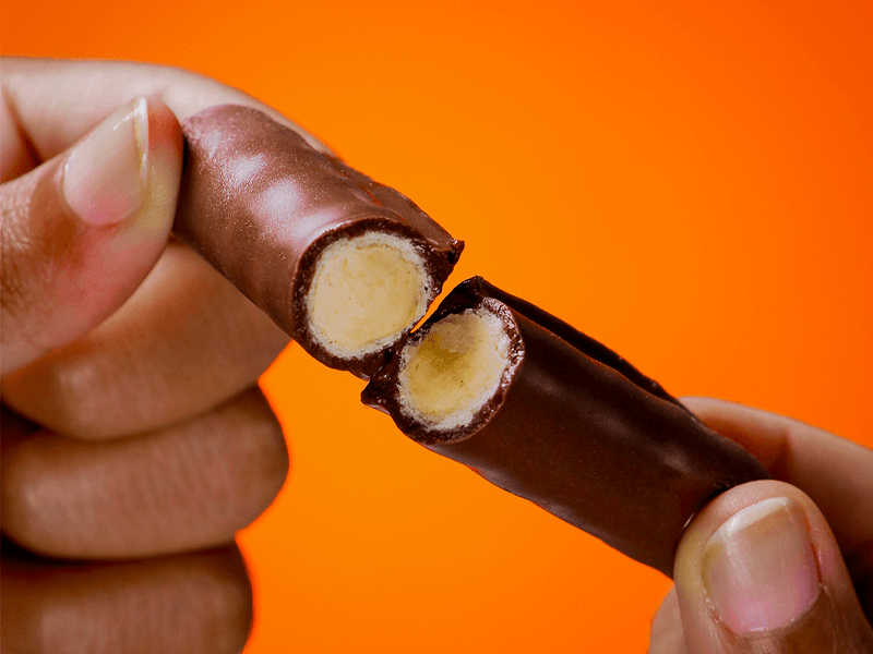 fundo laranja com tubinho de wafer sendo partido ao meio